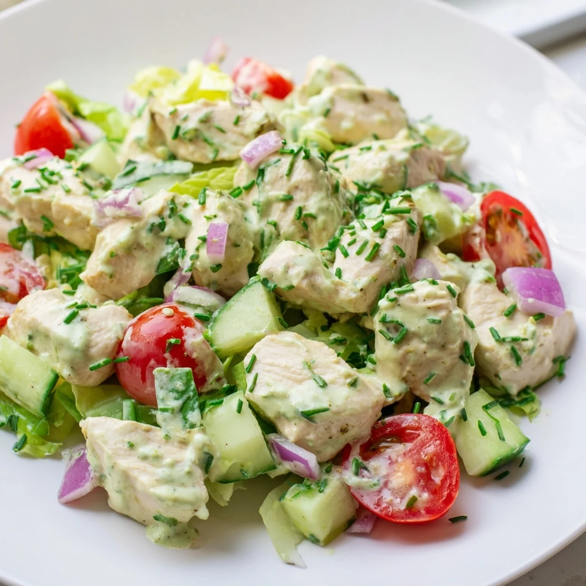 Creamy avocado ranch dressing coats tender chicken chunks, cherry tomatoes, and crisp cucumbers in this Avocado Ranch Chicken Salad served over mixed greens.  