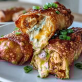 Freshly fried Buffalo Chicken Dip Egg Rolls show a golden crunch with a side of blue cheese dip.
