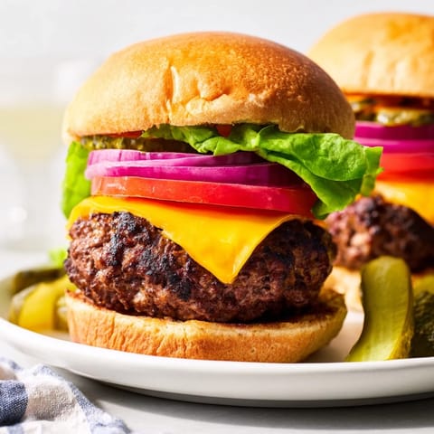 A close-up of delicious hamburgers, showing a perfectly cooked patty nestled in a toasted bun.