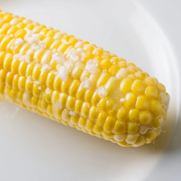 Grilled corn on the cob, with smoky char marks, ready to be slathered in butter and served hot.